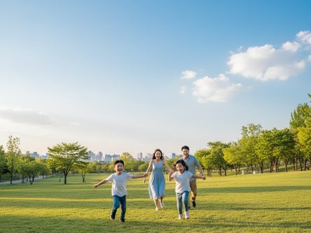 푸른 잔디밭 공원에서 아이 두 명이 부모와 함께 뛰어노는 모습, 봄철 맑은 하늘 배경
